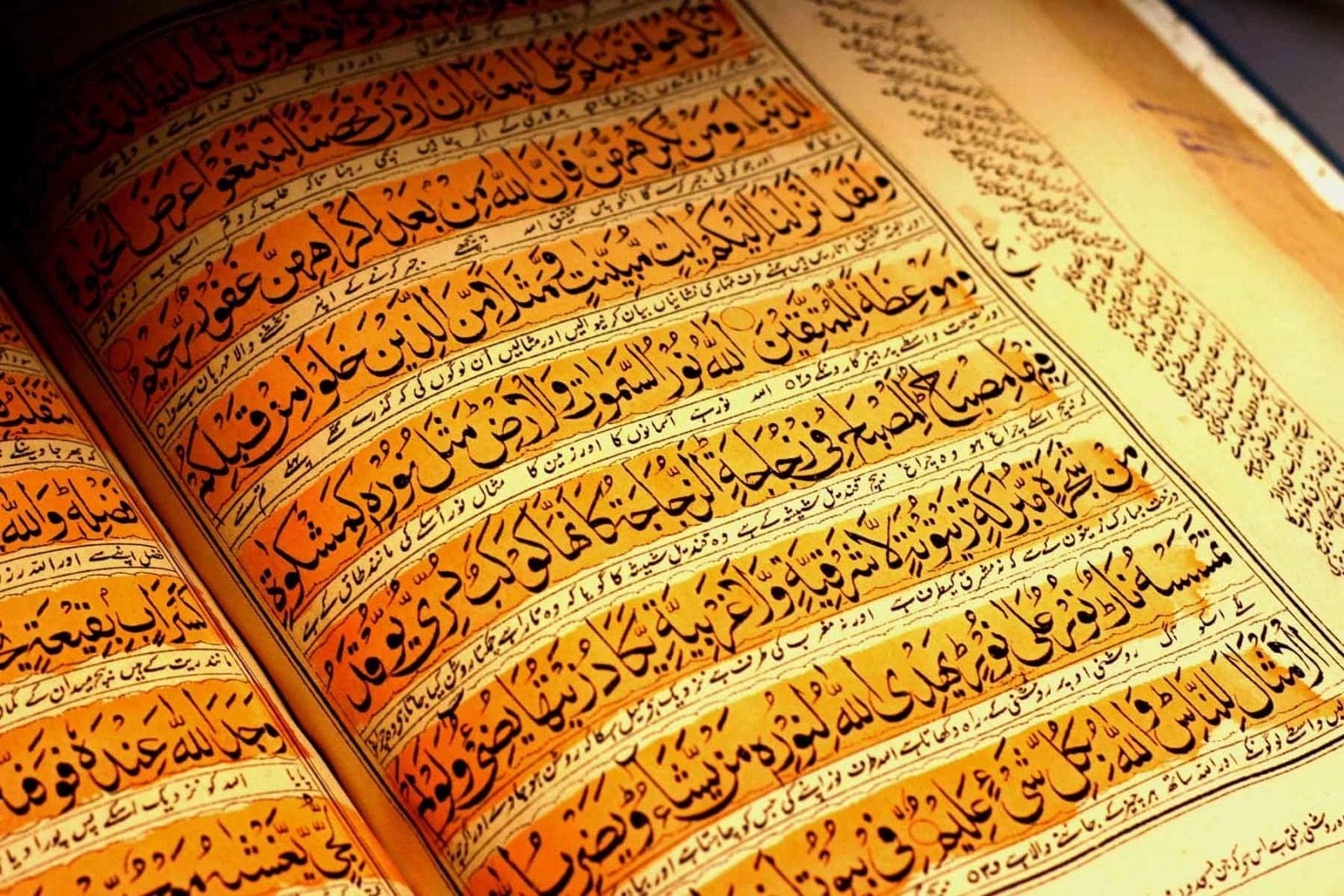 Close-up of illuminated Arabic calligraphy on the pages of an old Qur'an